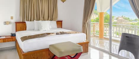 Une chambre d’hôtel comprenant un lit, une table de chevet, une chaise, un balcon avec vue et un appareil de climatisation.