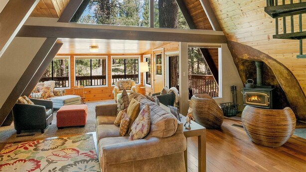 Un loft spacieux avec de hauts plafonds, de grandes fenêtres et un coin salon confortable agrémenté d’une cheminée.