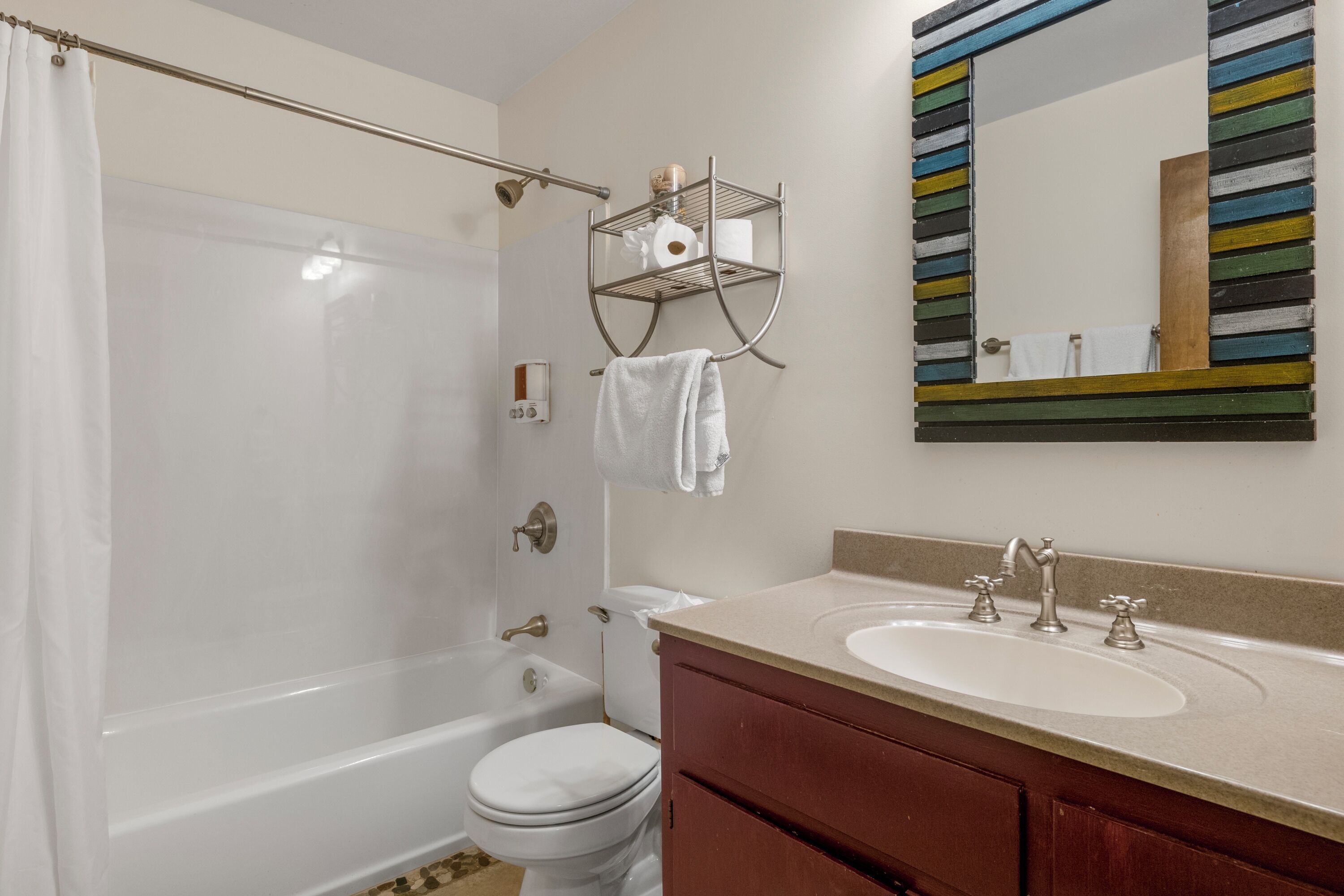 A bathroom with a bathtub, toilet, sink, and a towel rack.