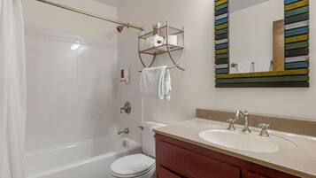 A bathroom with a bathtub, toilet, sink, and a towel rack.