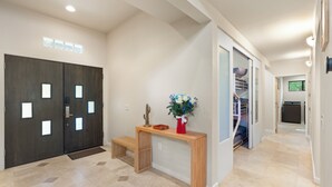 Un intérieur moderne avec un banc en bois, un vase de fleurs et un escalier menant à un niveau supérieur.