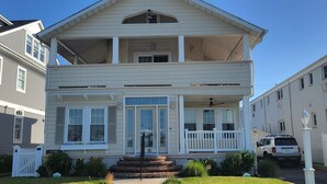 A two-story house with a front porch, a balcony on the upper floor, and a garage.