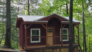 A cabin with a wooden exterior, a porch, and a door with windows. - Lazy T Cabins - Glacier (Graham County)