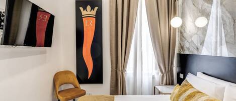 Habitación de hotel con cama, una silla, televisor, aire acondicionado instalado en la pared y un ventanal con cortinas.