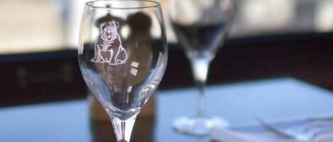Two empty wine glasses on a table with a city view in the background.