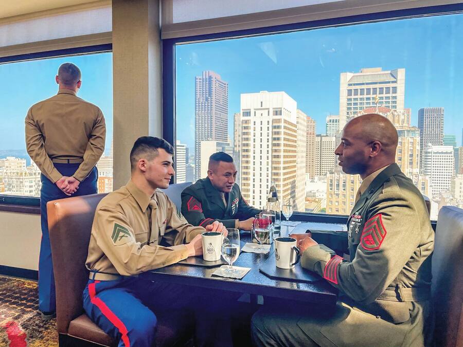 A group of people in uniform at a table with a city view.