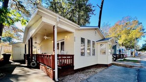 A small, single-story house with a porch, a garage, and a driveway.