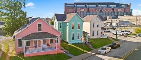 A row of colorful houses with a stadium in the background.