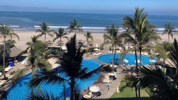 A resort with a pool area, lounge chairs, and a view of the beach and ocean. - Hotel Sea Garden, Nuevo Vallarta, Mexico. Sleeps 4 adults & 2 children. (Nuevo Vallarta)