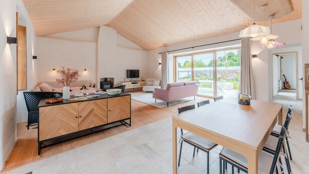 A spacious living area with a wooden ceiling, a dining table, a sofa, and a TV. - Grain d'Or - Proche Noirmoutier - Jardin (Bouin)