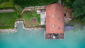 Luchtbeeld van een gebouw met een plat dak, een klein terras en een helder uitzicht op het water.