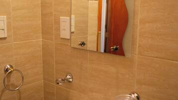 A bathroom with a sink, mirror, and towel ring.