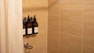 Standaard tweepersoonskamer | Badkamer | Een douche, handdoeken, zeep, shampoo