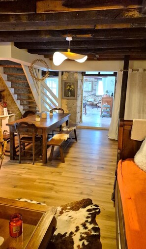 Un intérieur rustique avec un escalier en bois, un coin repas et un espace salon confortable.