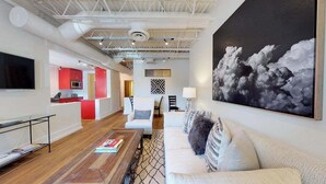A modern living room with a sofa, coffee table, and artwork on the wall.