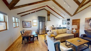 A spacious living area with a dining table, sofa, and coffee table.