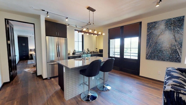 A modern kitchen with a central island, bar stools, and a large window. - The Lincoln 302, 1 Bed / 1 Bath, Luxury Condo (Santa Fe)