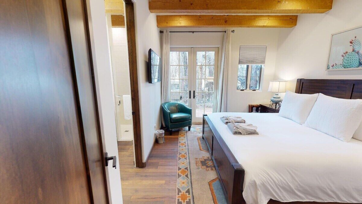 Une chambre à coucher avec un lit, une chaise, une table de chevet et une fenêtre.