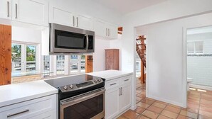 A modern kitchen with white cabinetry, a built-in microwave, and an oven. - Large  Ocean Front, Loft House with 3 beds, 2 baths in Key Largo with Boat Dock (Key Largo)