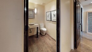 A modern bathroom with a sink, toilet, and framed artwork on the wall. - The Lincoln 402, 2 Bed / 2.5 Bath, Luxury Condo (Santa Fe)