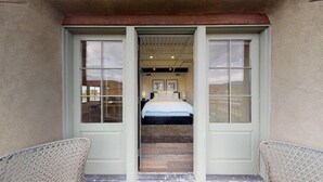 L’entrée d’une chambre d’hôtel, avec un lit, deux chaises et une vue sur l’intérieur de la pièce.