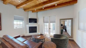 A living room with a fireplace, leather sofa, and a green armchair.