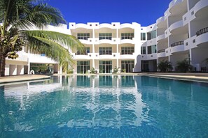 A swimming pool with a white building in the background.