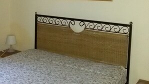 Una habitación con una cama, una mesita de noche, una lámpara y un cuadro en la pared.