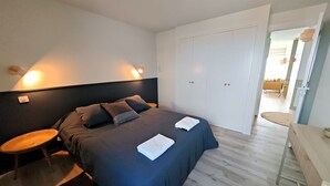 Une chambre à coucher avec un lit, une table de chevet et une armoire.
