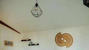 Ein Schlafzimmer mit Bett, Schreibtisch, Stühlen und einer Pendelleuchte.