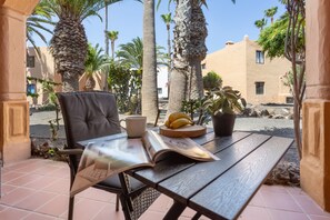 Une table avec un magazine, une tasse et une assiette contenant des bananes.
