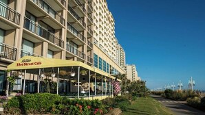 Hotel con una cafetería 33rd Street en la planta baja, con terraza al aire libre y plantas, y una bandera estadounidense.