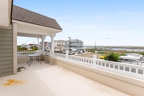 A balcony with a view of a beach and houses. - Charming newly updated home in Avalon with endless views of bay and sunset (Avalon)