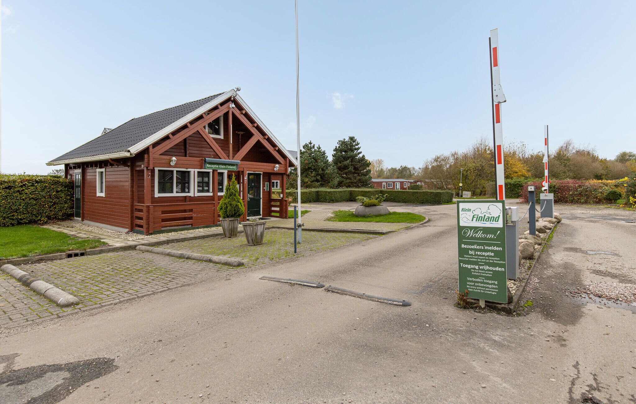 Ein Empfangsgebäude mit einem Schild, auf dem "Reception Klein Finland" steht, und einem Willkommensschild für Besucher.