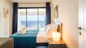 A hotel room with a bed, bedside table, and a view of the sea. - Florida Soleil luxury and sea view (Schoelcher)