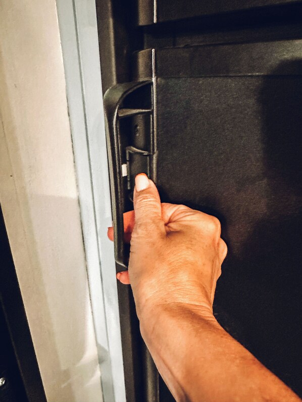 A hand opening a door with a metallic handle. - Starlight Retreat RV in Springtown with AC, WiFi (Springtown)