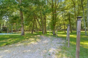 Une zone boisée avec un sentier de gravier et des poteaux en bois.