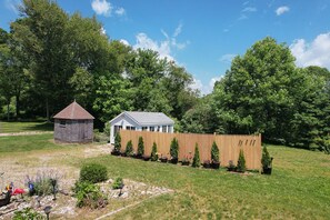 A garden with a wooden fence, a small shed, and a conservatory.