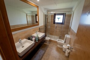 Een douche, een bidet, handdoeken, toiletpapier