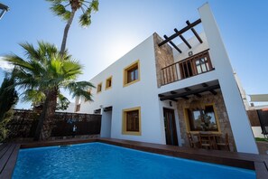 A modern two-story house with a swimming pool, a patio area, and a stone facade. - Villa Can Rusiniol, 2 (Puig d'en Valls)