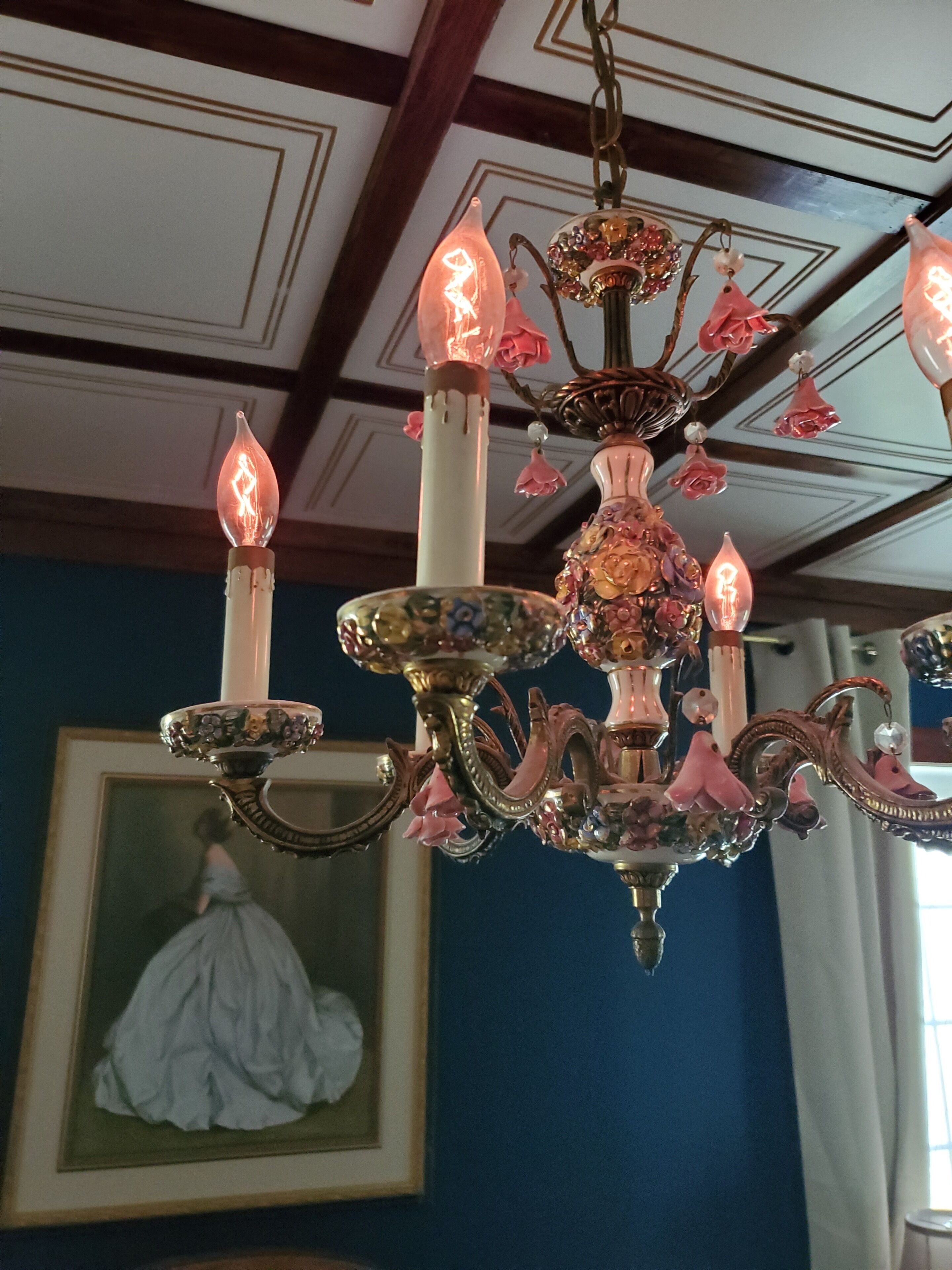 Un candelabro con múltiples luces que simulan velas y adornos florales.