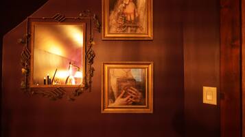 A wall with two framed pictures and a mirror.