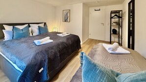 A bedroom with a large bed, a bedside table, a wardrobe, and a mirror. - 5-7 persons, Wifi, terrace, new, near Nordpark and supermarkets BIELEFELD (Bielefeld)
