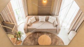 A modern living room with a sofa, a round wooden coffee table, and a potted plant. - Unique 3 floor tower apartment with AC at Westerpark (Amsterdam)
