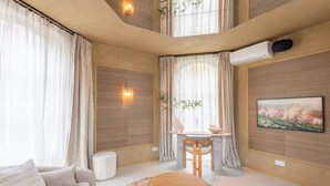 A modern living room with a sofa, a round wooden table, and a dining area with a chair. - Unique 3 floor tower apartment with AC at Westerpark (Amsterdam)