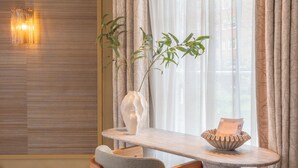 A modern room with a round table, a chair, a vase with a plant, and a wall-mounted light fixture. - Unique 3 floor tower apartment with AC at Westerpark (Amsterdam)