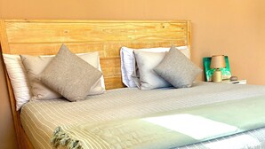 A wooden bed with a striped bedspread and multiple pillows. - 7-min Walk to Beach, King Bed, Jacuzzi Costa Caribe Studio (Noord)