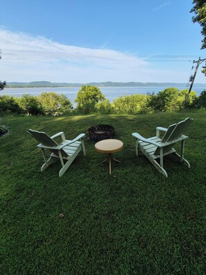 A grassy outdoor area with two Adirondack chairs and a small round table. - Enchanting 3-bedroom house with WiFi in Genoa (Genoa)