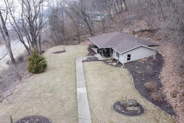 A single-story house with a sloped roof, a covered porch, and a small front yard.