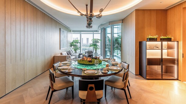 Un comedor moderno con una mesa redonda, sillas y una lámpara de techo original.